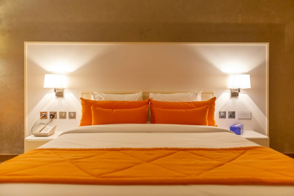 Clean fresh sheets in the bright orange bedroom at the hotel